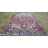 A North West Persian Woollen Carpet with a Central Medallion within an All Over Design upon a