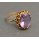 A 9ct. Gold Amethyst Dress Ring with a large oval amethyst within a pierced setting