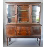 A 20th Century Bookcase, the moulded cornice with blind fret work frieze above three glazed doors,