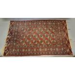 A Bokhara Woollen Rug with three rows of guls upon a red and cream ground within multiple borders,