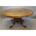 A Victorian Burr Walnut Centre Table of Oval Form with a heavy carved centre column and