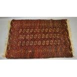 A Bokhara Woollen Rug with three rows of guls upon a red ground within multiple borders, 161 x 110