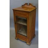 An Edwardian Mahogany Shell and Satinwood Inlaid Music Cabinet with a glazed door enclosing