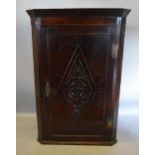 A 19th Century Oak Hanging Corner Cabinet with a carved door