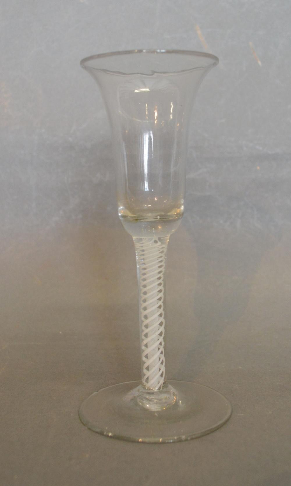 An 18th Century Drinking Glass, the bell shaped bowl above an opaque twist stem and plain conical