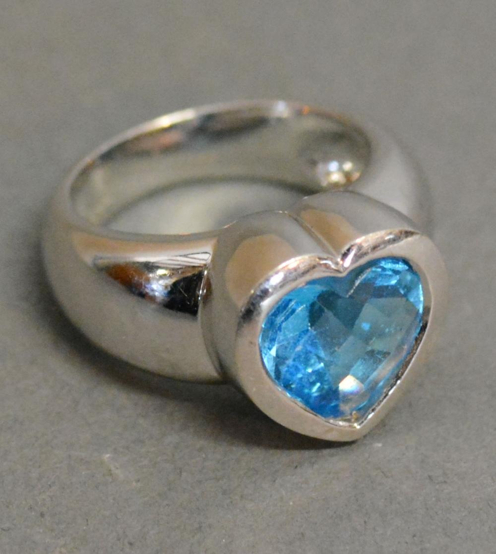 An 18ct. White Gold Ring in the form of a Heart set Pale Blue Stone