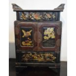 A Late 19th Early 20th Century Japanese Lacquered Table Cabinet with two doors enclosing drawers