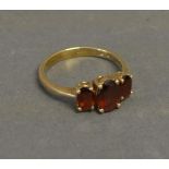 A 9ct. Yellow Gold Dress Ring set with three garnets within a pierced setting