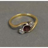 An 18ct. Yellow Gold Ruby and Diamond Ring set with single ruby opposed by two diamonds within a