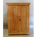 A 19th Century Pine Cabinet, the moulded top above two panel doors with knob handles, raised upon