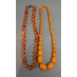 A Graduated Amber Bead Necklace together with another similar amber bead necklace