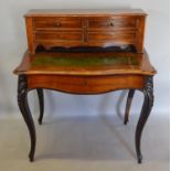 A Victorian French Rosewood Writing Desk, the shaped top with four drawers above a pull-out