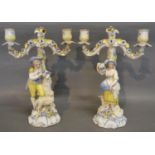 A Pair of German Porcelain Twin Branch Candelabrum with figural columns, 28 cms tall