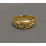 An 18ct. Gold Three Stone Diamond Gypsy Ring set with three graduated diamonds