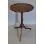 A Regency Mahogany Occasional Table, the moulded dish top above a ring turned column and outswept