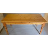 A 20th Century Pine Farmhouse Kitchen Table of rectangular form with a plank top raised upon