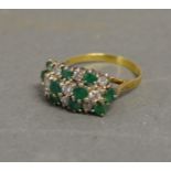 An 18ct. Yellow Gold Emerald and Diamond Ring with three bands of diamonds and emeralds within a
