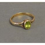 A 9ct. Yellow Gold Dress Ring set with oval peridot