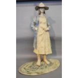 A Large Pottery Figure in the form of a Girl wearing a Hat, 63 cms tall