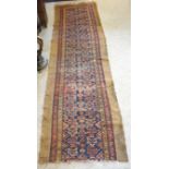 A North West Persian Woollen Runner with an all over design upon a red, blue and cream ground within