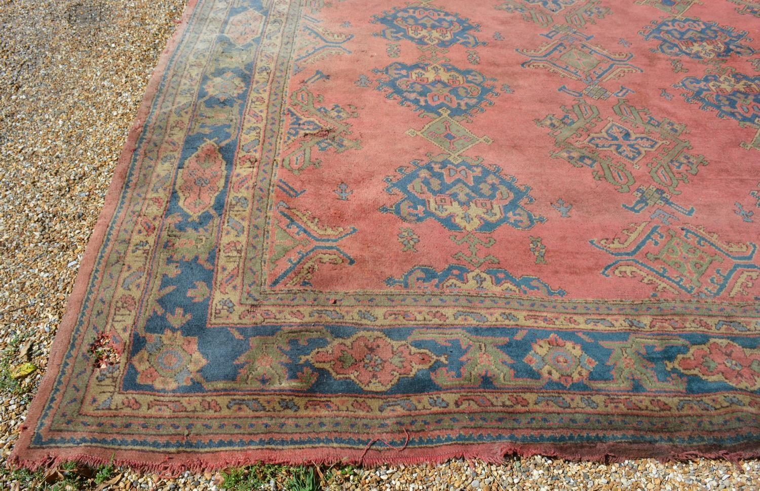 A Large Turkish Woollen Carpet with three rows of guls upon a red, blue and cream ground within - Image 3 of 6