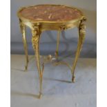 A French Gilt Metal Center Table, the rouge marble top above a shaped frieze, raised upon cabriole