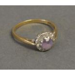 A 9ct. Yellow Gold Cluster Dress Ring set with central pink stone surrounded by diamonds within a