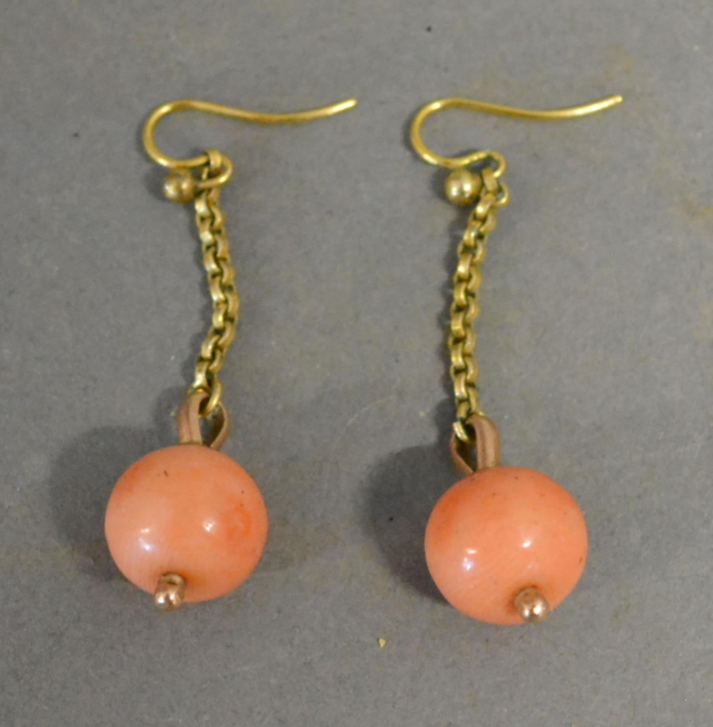 A Pair of Yellow Metal Drop Earrings both with coral bead drops