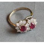 An 18ct. White Gold Ruby and Diamond Double Crossover Ring set with two rubies surrounded by