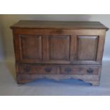 A George III Oak Mule Chest, the hinged moulded top above a three panel front and two drawers with