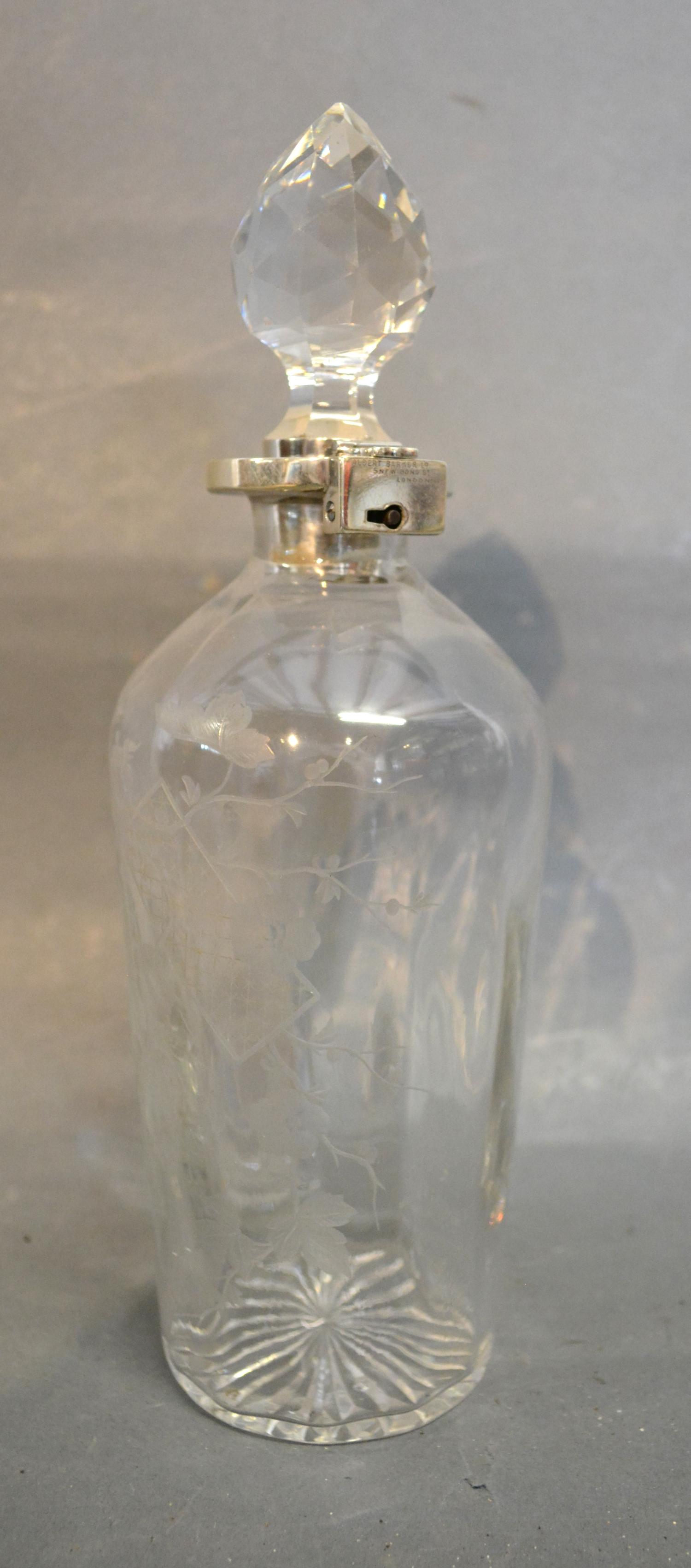 A Victorian Silver Mounted and Cut Glass Decanter with locking mechanism etched with birds amongst