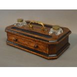 A Victorian Walnut And Ebonised Ink Stand with two glass ink bottles above a drawer with brass