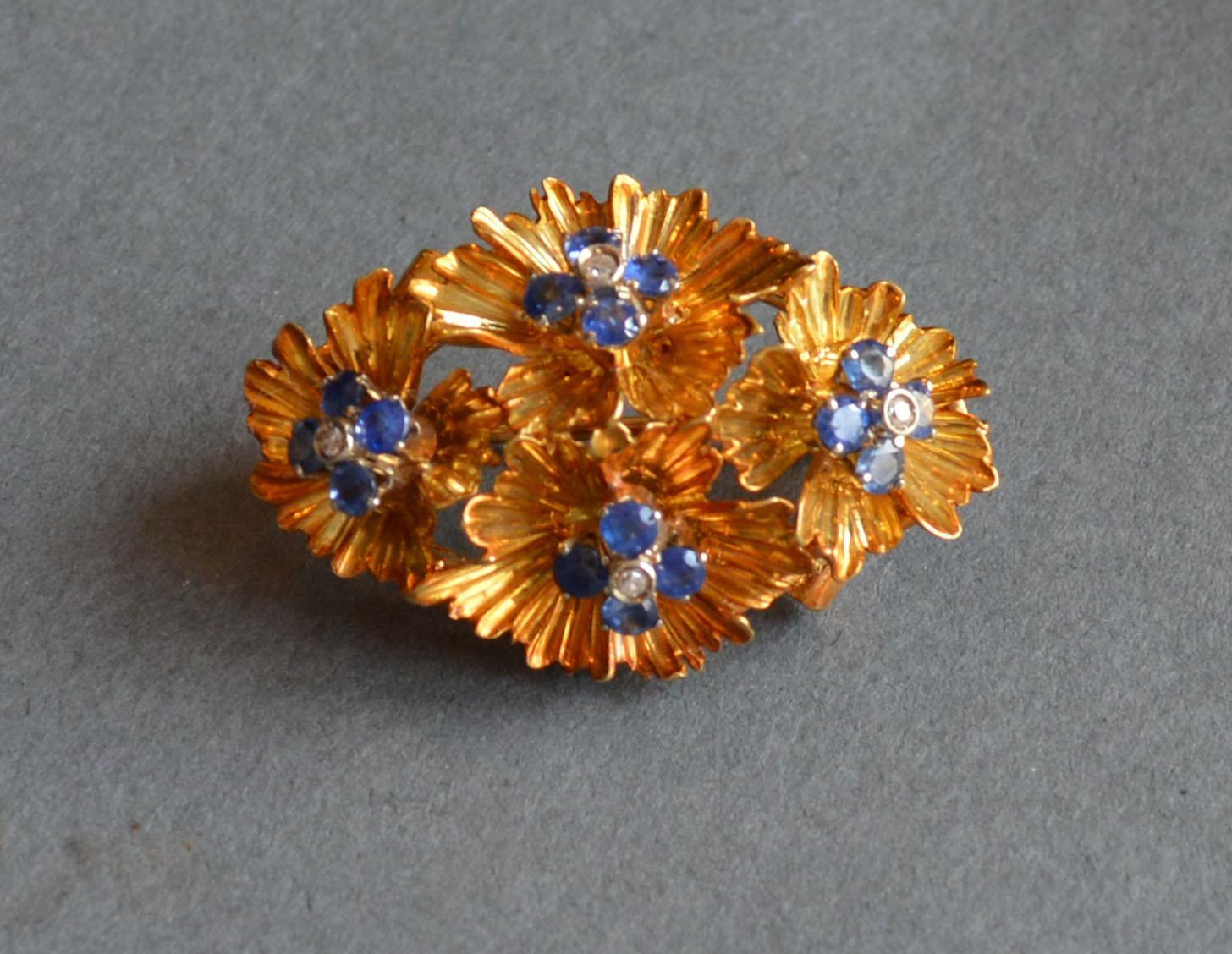 An 18ct. Gold Diamond and Sapphire Brooch of multiple flower head form, marked 750, 9.8 gms, 3.4