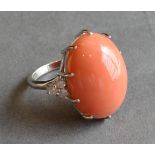 An 18 ct. White Gold, Coral and Diamond Set Ring, with a large cabochon claw set oval Coral