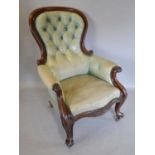 A Victorian Mahogany Green Leather Library Armchair with a button upholstered back above a
