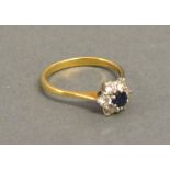 An 18 ct. Yellow Gold, Diamond And Sapphire Cluster Ring, with a central sapphire surrounded by