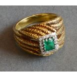An 18ct. Yellow Gold, Emerald and Diamond Ring, a central square emerald surrounded by diamonds,