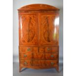 A Regency Mahogany Press Cupboard With A Shaped Cornice above a pair of oval inlaid doors