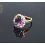 A Yellow Gold Amethyst And Diamond Ring set with a large oval amethyst surrounded by diamonds claw