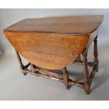 A George III Oak Oval Gate Legged Dining Table With An End Drawer, raised upon turned legs with