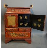 A Japanese Lacquered Table Cabinet With Gilded Decoration upon a red ground and two doors