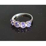 A 9ct. White Gold Tanzanite And Diamond Ring set with four oval tanzanite inter-spaced with six