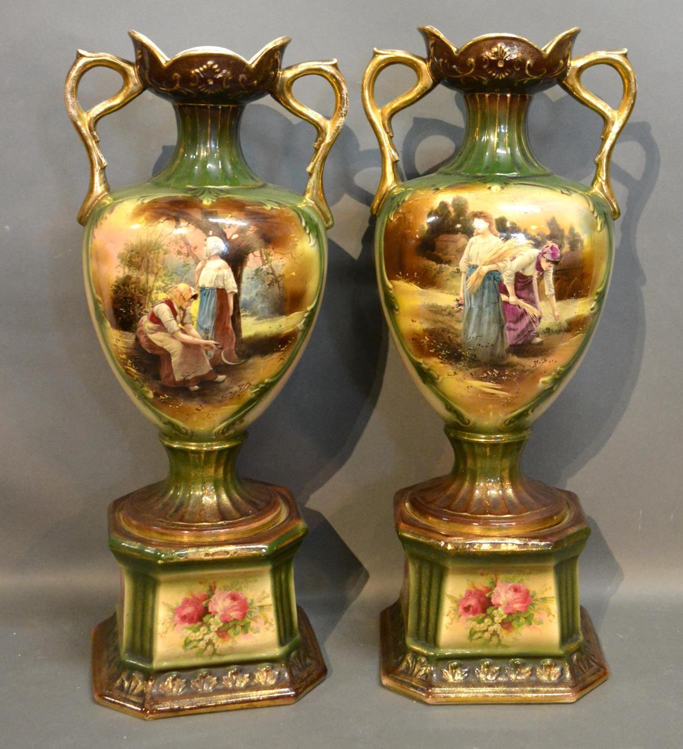 A Pair Of Victorian Two Handled Vases Decorated With Figures within landscapes highlighted with