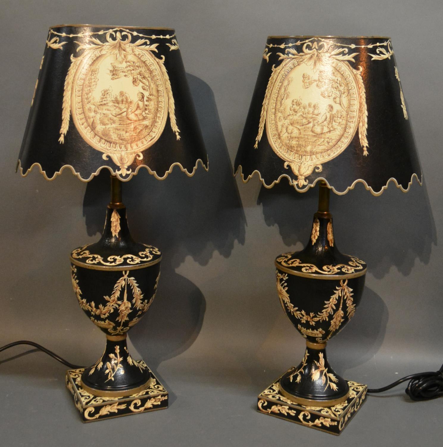 A Pair Of Tole-Ware Table Lamps Of Oviform Decorated Bows And Swags upon a black ground and with