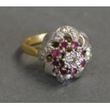 A Diamond And Ruby Cluster Ring With A Central Diamond surrounded by rubies within a pierced setting