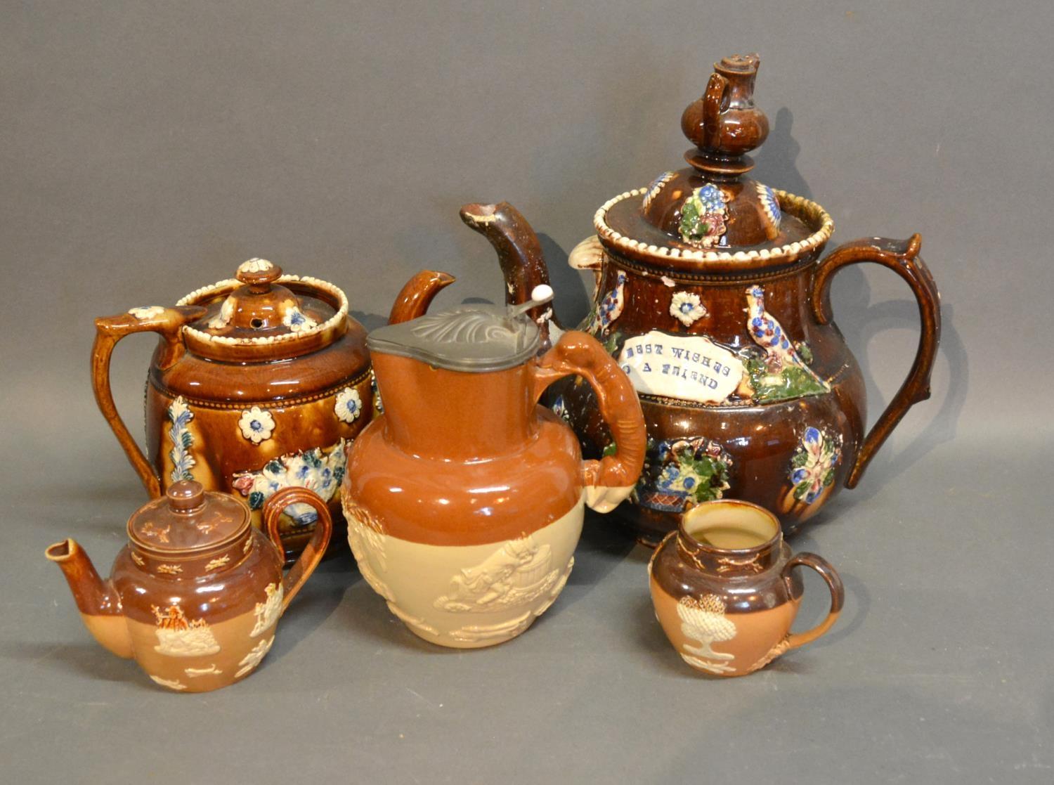 A Bargeware Large Teapot Decorated In Relief, together with another similar and three stoneware