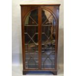 A 19th Century Mahogany Bookcase With Two Astragal Arch glazed doors enclosing shelves, raised