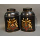 A Pair Of Tole-Ware Canisters Each Decorated With A Coat Of Arms upon a black ground, 35cm tall