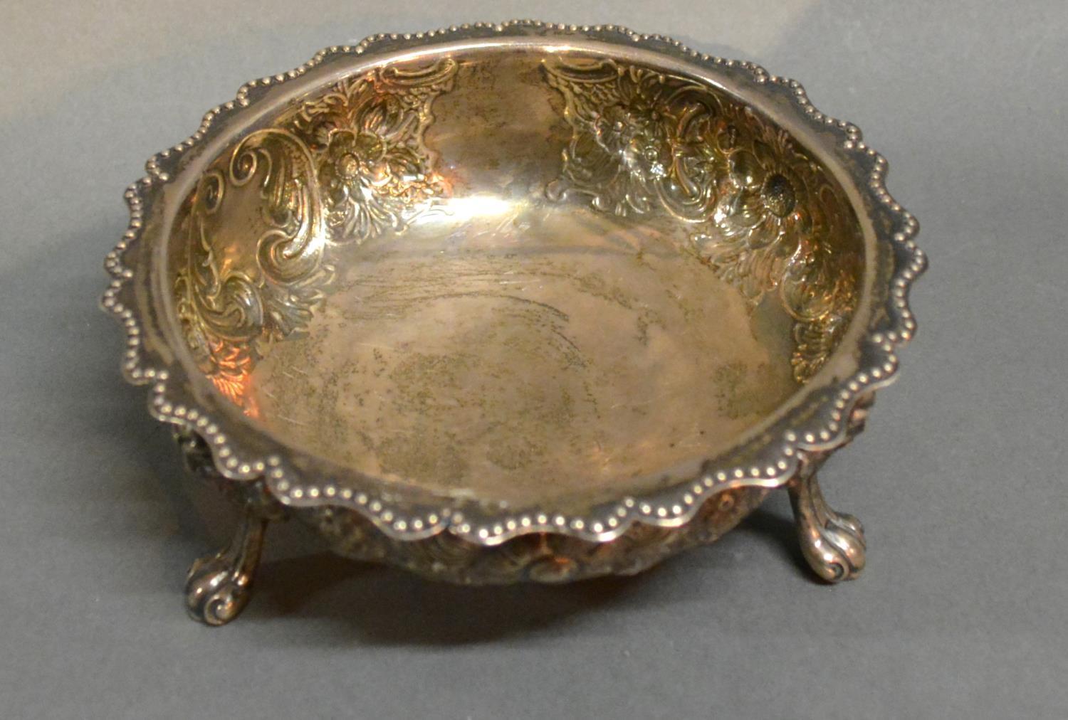 A Victorian Silver Bowl With Embossed Decoration , raised upon three scroll feet, London 1886, by