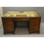 An Early 20th Century Mahogany Twin Pedestal Desk, the green tooled leather inset top above nine